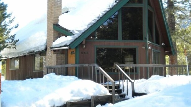 A cabin with a chimney, large windows, and a porch. - 842 Cirugu (South Lake Tahoe)