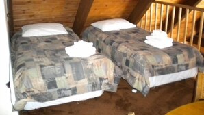 A small, cozy room with two beds, wooden beams, and a simple, rustic design. - 842 Cirugu (South Lake Tahoe)
