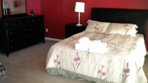 A bedroom with a bed, a dresser, a nightstand, and a mirror. - 2728 Springwood Dr. (South Lake Tahoe)