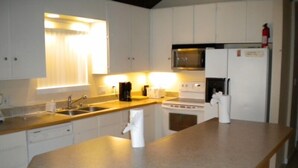 A compact kitchen with a sink, stove, microwave, and refrigerator. - 2728 Springwood Dr. (South Lake Tahoe)