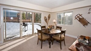 A dining area with a round table and chairs, a bowl of fruit, and a lamp. - 2853 Springwood Dr. (South Lake Tahoe)