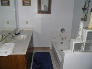 A bathroom with a double sink, a bathtub, and a mirror. - 3832 Regina Rd. (South Lake Tahoe)