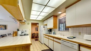 A kitchen with white cabinets, a dishwasher, and a wooden countertop. - 3221 Marlette Circle (South Lake Tahoe)