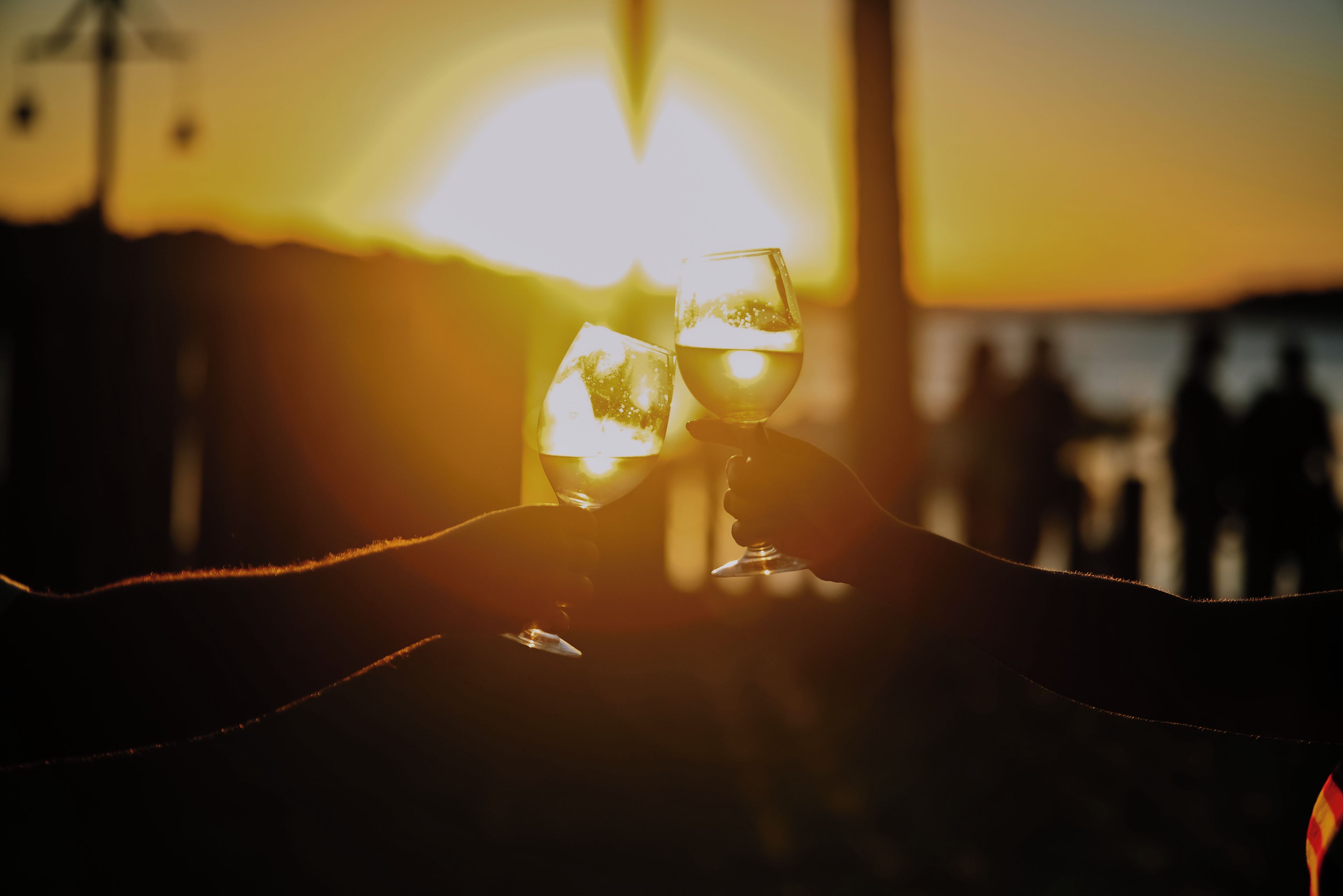 Dois copos de um líquido transparente, possivelmente água, com um pôr do sol ao fundo.