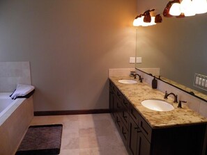 A bathroom with two sinks, a mirror, and a towel rack. - 3354 Red Lake Rd (South Lake Tahoe)