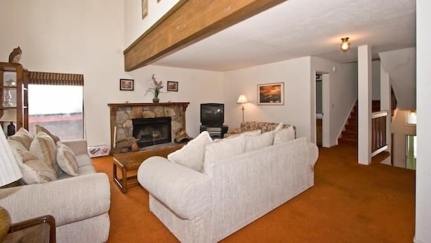 A living room with a fireplace, a sofa set, and a television.