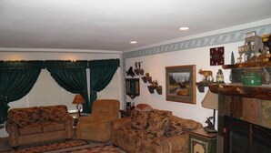 A living room with two sofas, a fireplace, and wall-mounted decor.