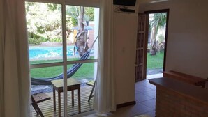 Une chambre avec vue sur une piscine, un hamac et un espace patio.