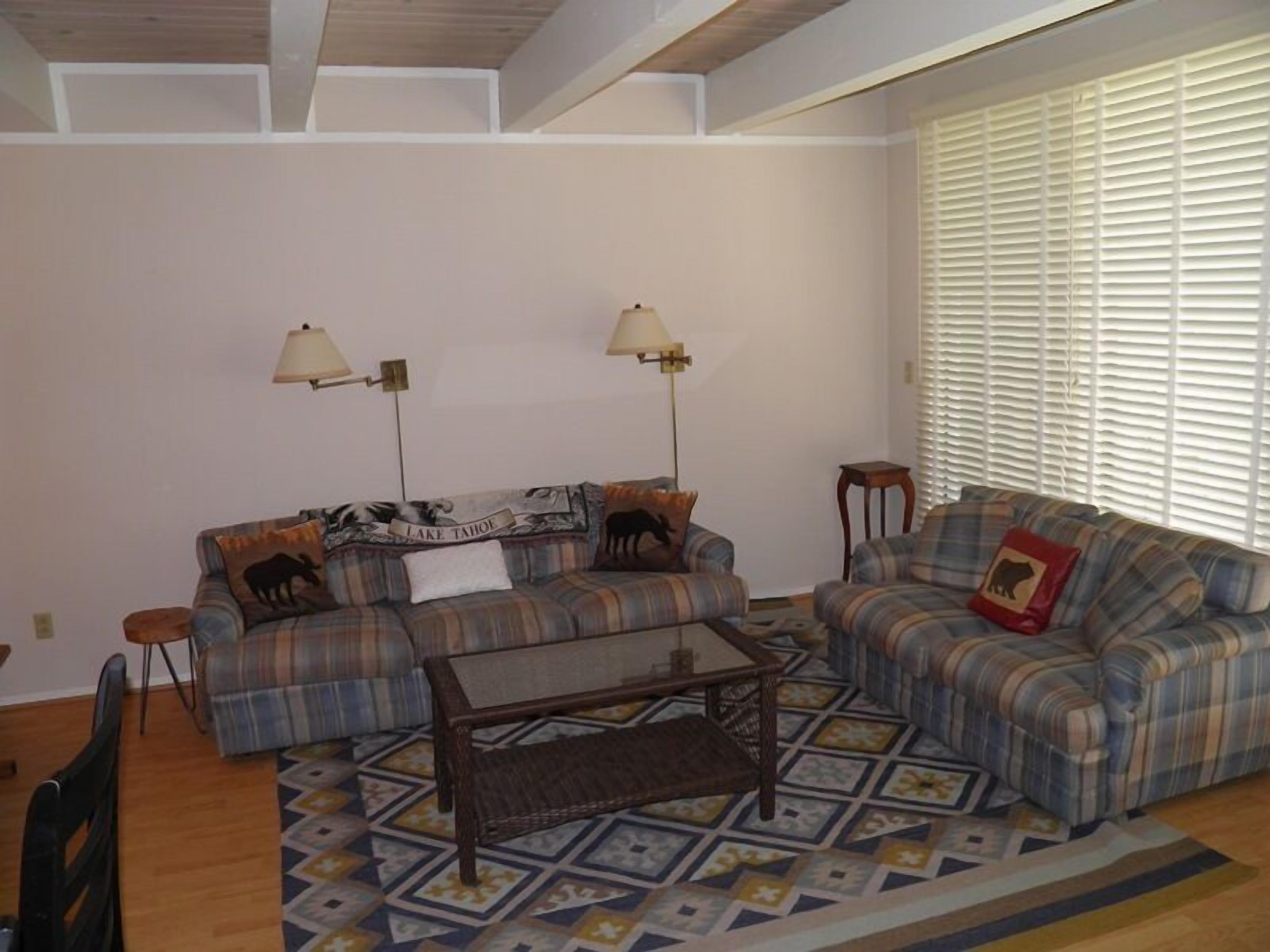 A living room with two sofas, a coffee table, and two floor lamps.