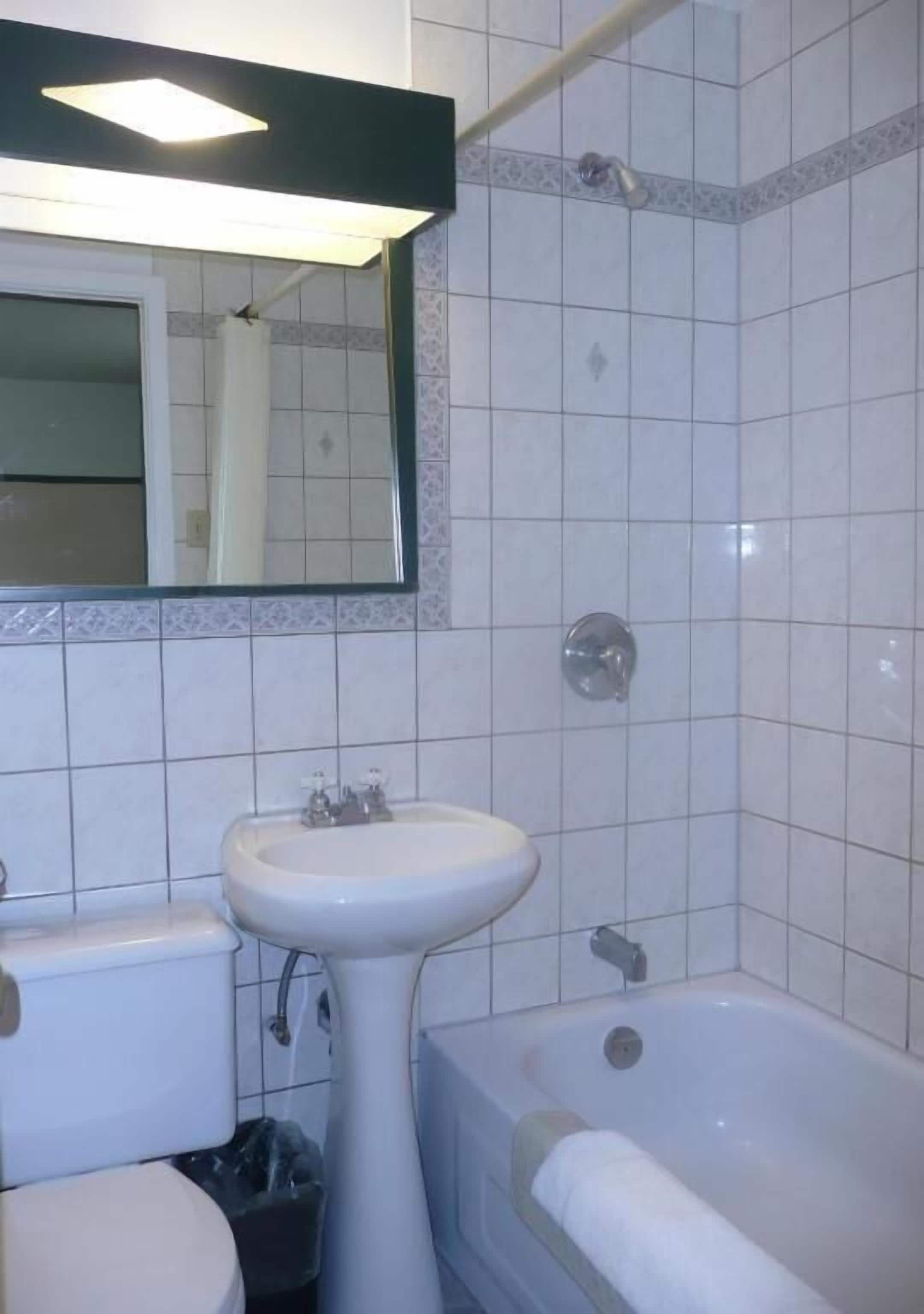 Un baño con lavamanos, inodoro y bañera.