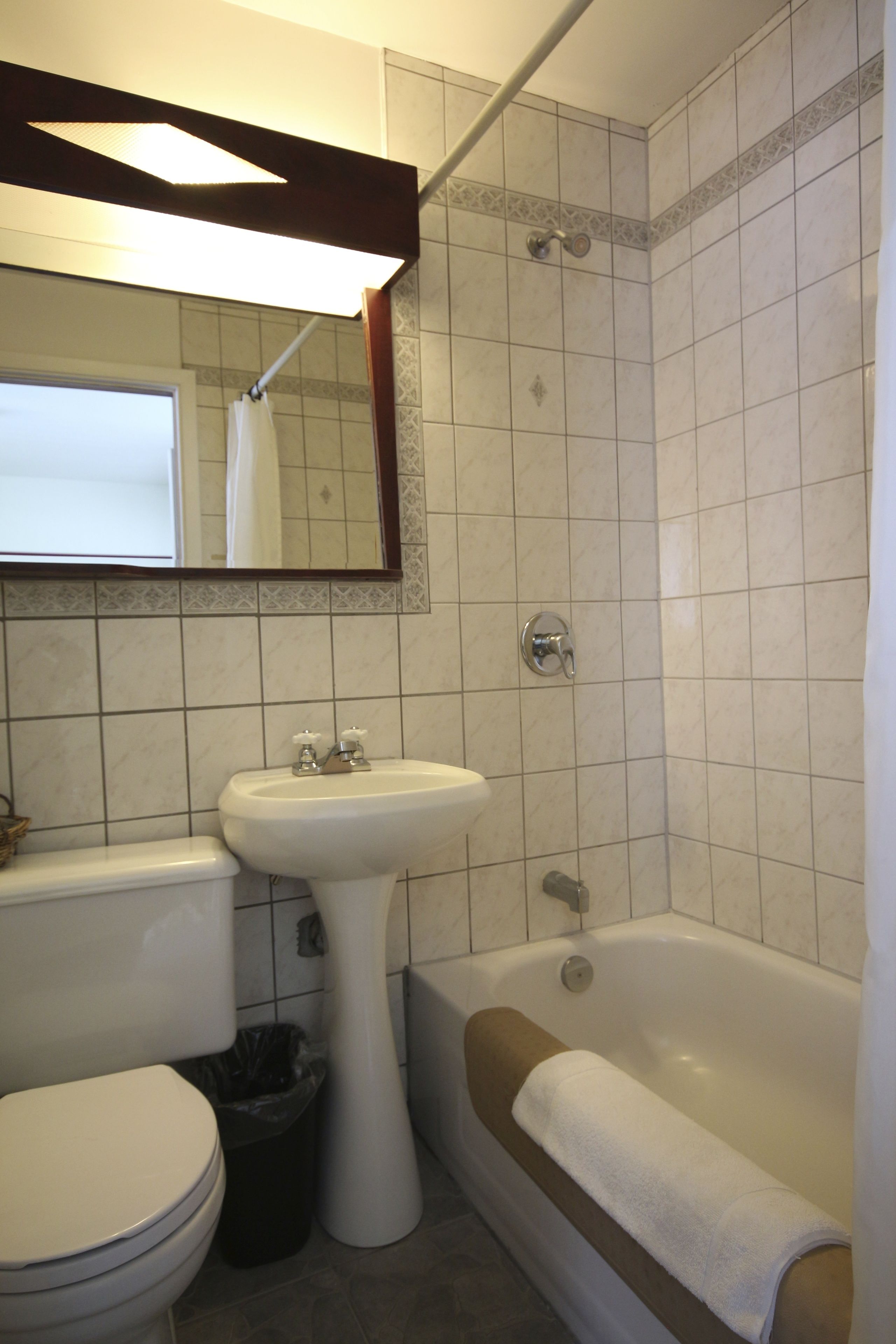A bathroom with a toilet, sink, and bathtub.