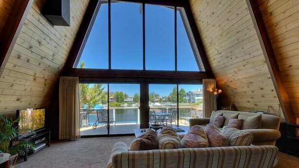 A cozy living room with a large window overlooking a pool and outdoor seating area.