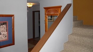 A staircase with a wooden handrail leading to a landing. - 584 Alpine Dr (South Lake Tahoe)