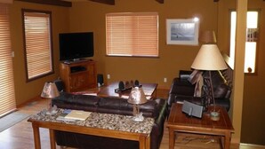 A living room with a television, a sofa, a coffee table, and a lamp. - 584 Alpine Dr (South Lake Tahoe)