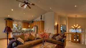 Ein geräumiges Wohnzimmer mit einer großen Couch-Garnitur, einem Couchtisch und einem Deckenventilator.