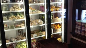 Een bakkerij met planken vol gebak en een vitrine met vers fruit.