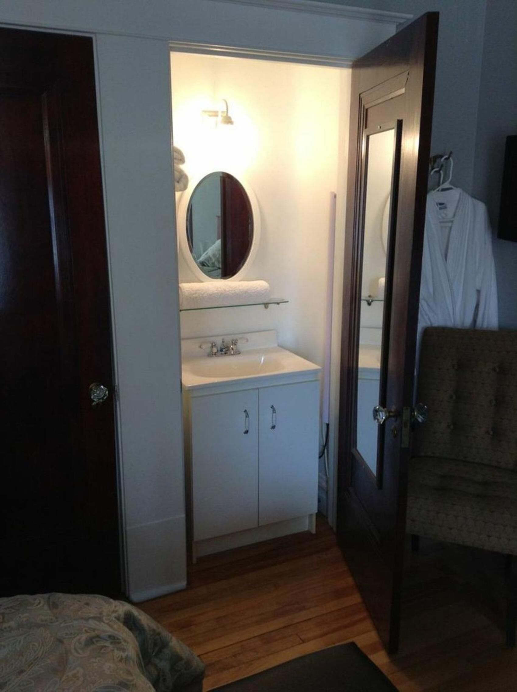 A small bathroom with a mirror, sink, and cabinet.