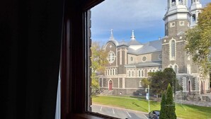 Een uitzicht op een historisch kerkgebouw met een opvallende klokkentoren en een groot rondboogvenster.
