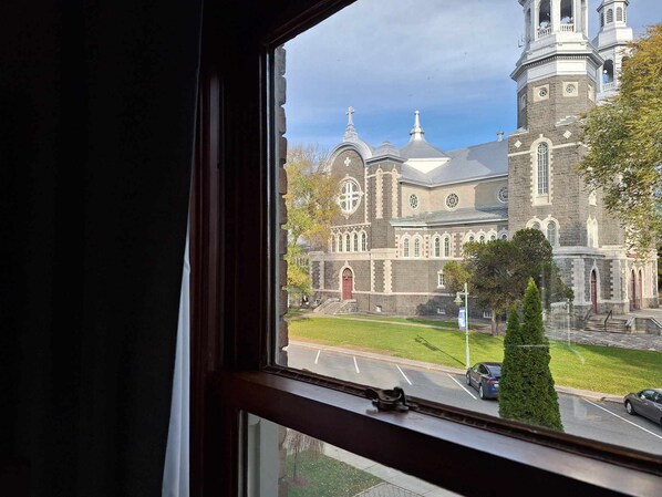 Vista de una iglesia histórica con un campanario destacado y un amplio ventanal de arco.