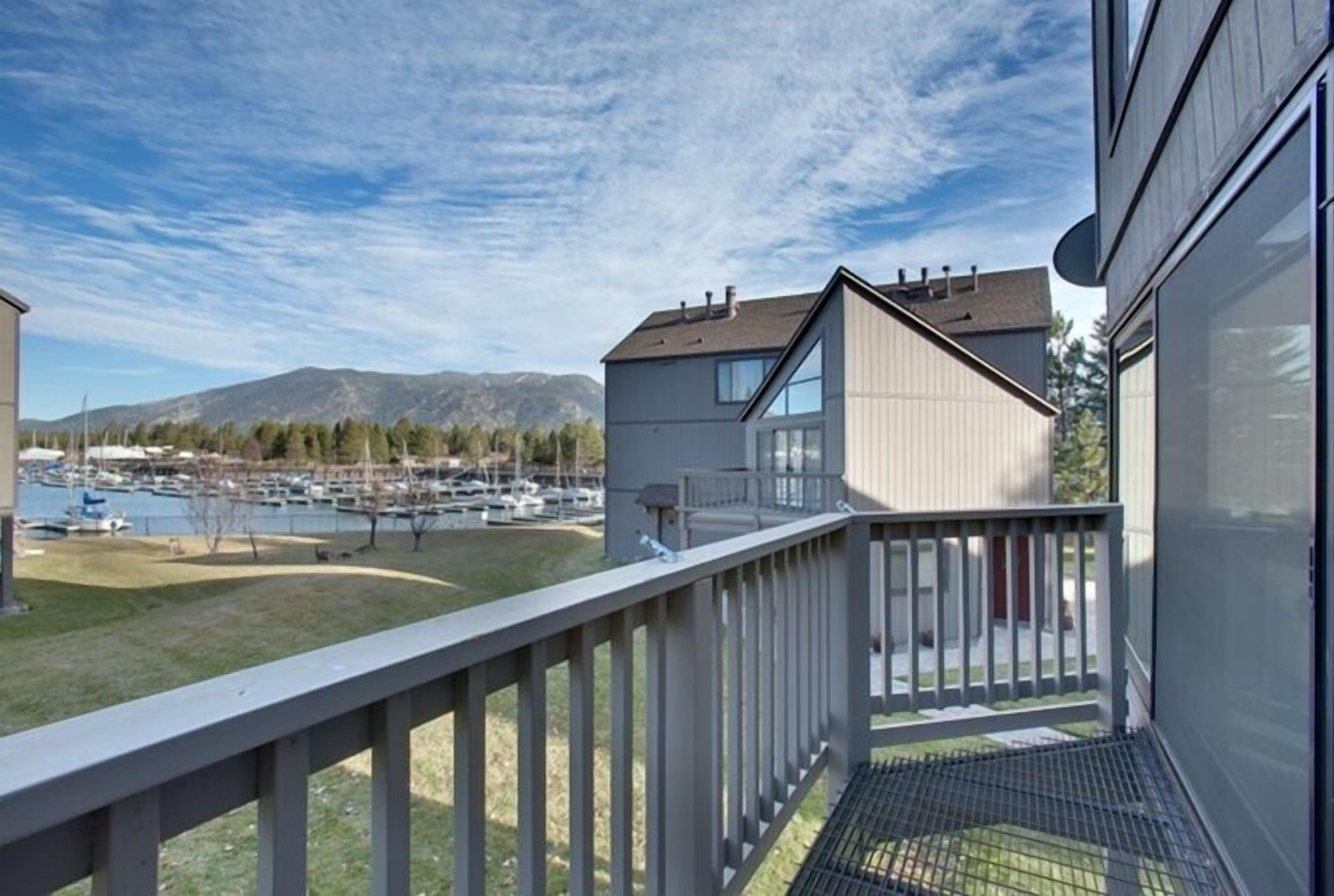 A balcony with a view of a marina and mountains.