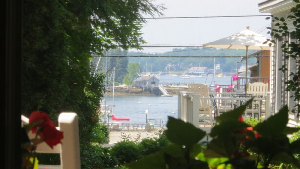 A view from a balcony overlooking a marina with boats, a bridge, and buildings in the background. - Atlantic Ark Inn (Boothbay Harbor)