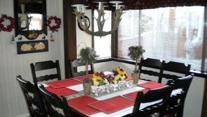 A dining area with a square table set for six, surrounded by six chairs. - 528 Tahoe Keys Blvd (South Lake Tahoe)