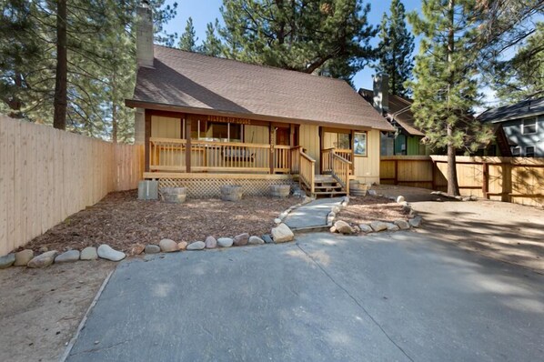 A lodge with a wooden exterior, a porch, and a stone pathway leading to the entrance.