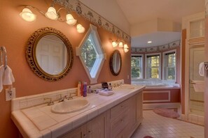 Un baño con dos lavamanos, un espejo grande y una ducha.