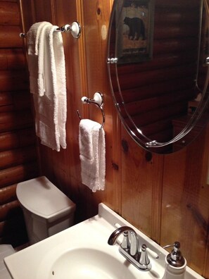 A bathroom with wooden walls, a white sink, and two towels hanging on towel hooks. - 2657 Kubel (South Lake Tahoe)