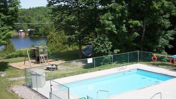 Una piscina al aire libre de temporada, tumbonas