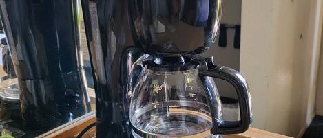 A coffee maker with a tray of coffee pods and a cup of coffee.