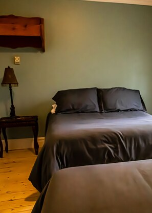 A bedroom with a bed, a nightstand, and a lamp. - Auberge Les Deux Tours (Saguenay)
