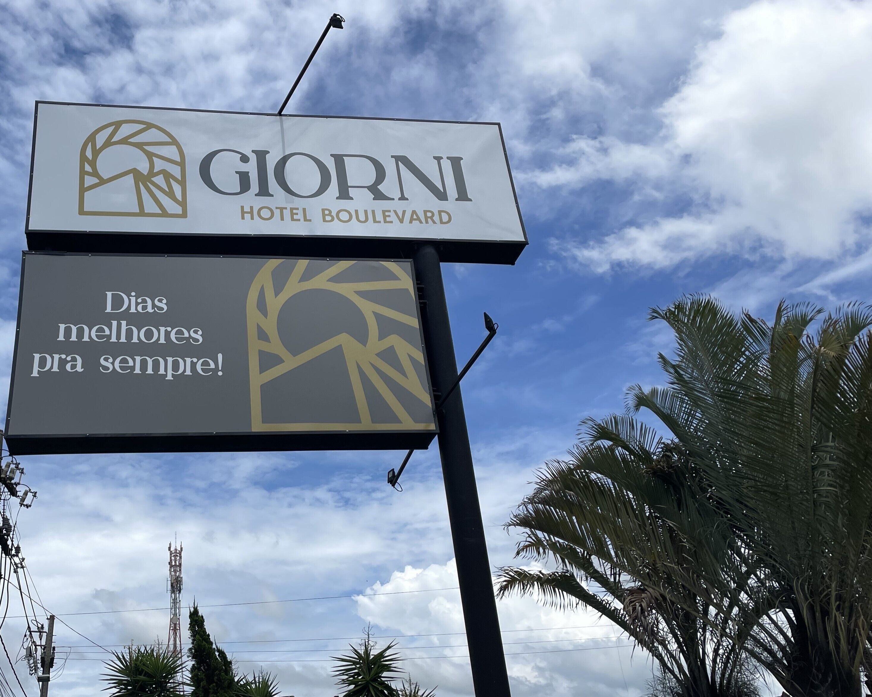 Placa de hotel com o nome 'GIORNIA HOTEL BOULEVARD' e o slogan 'Dias melhores para sempre!'.