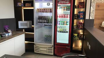 A compact kitchenette with a mini-fridge, microwave, and a Coca-Cola cooler.