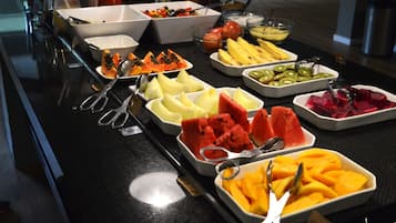 A buffet with various fruits and vegetables.