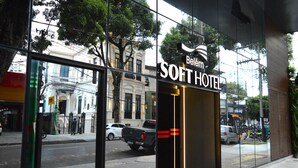 A hotel entrance with a glass facade, a sign reading "Belém Soft Hotel," and a reflection of the street and buildings. - Belém Soft Hotel (Belém)