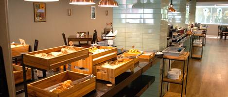 Een buffetopstelling met houten serveerplanken en koperen hanglampen.
