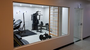 A gym with exercise equipment, a treadmill, and a mirror reflecting the space. - Belém Soft Hotel (Belém)