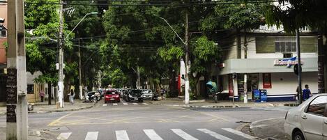 A street view with a crosswalk, parked cars, and buildings including one with a sign that reads "Extra Inn".