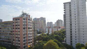 Un edifici residencial alt amb nombroses plantes, balcons i un entorn urbà dens, amb altres edificis al fons.