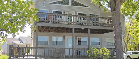 Un immeuble de deux étages doté d’un balcon à l’étage supérieur, entouré de verdure.