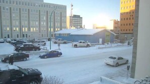 A snowy urban street with parked cars and buildings. - Yellowknife Polar Suite (Yellowknife)