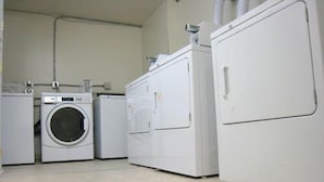 A laundry room with three stacked washers and dryers. - Yellowknife Polar Suite (Yellowknife)