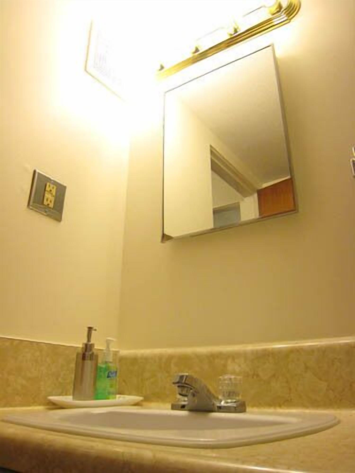 A bathroom with a sink, mirror, and toiletries.