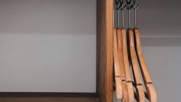Un estante de madera con varios utensilios de cocina colgando en un soporte metálico.