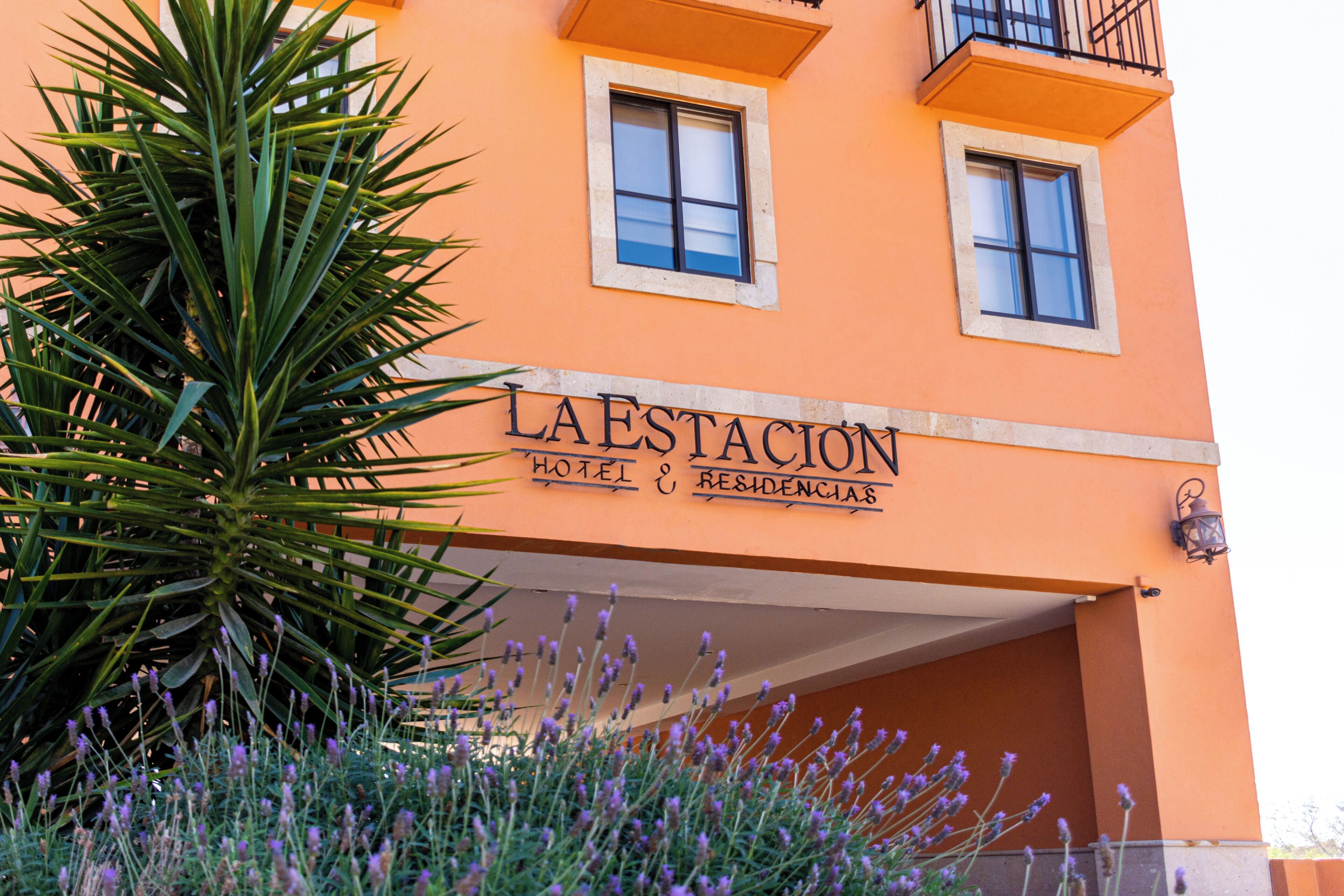 A building with the sign "LA ESTACION HOTEL & RESIDencias".