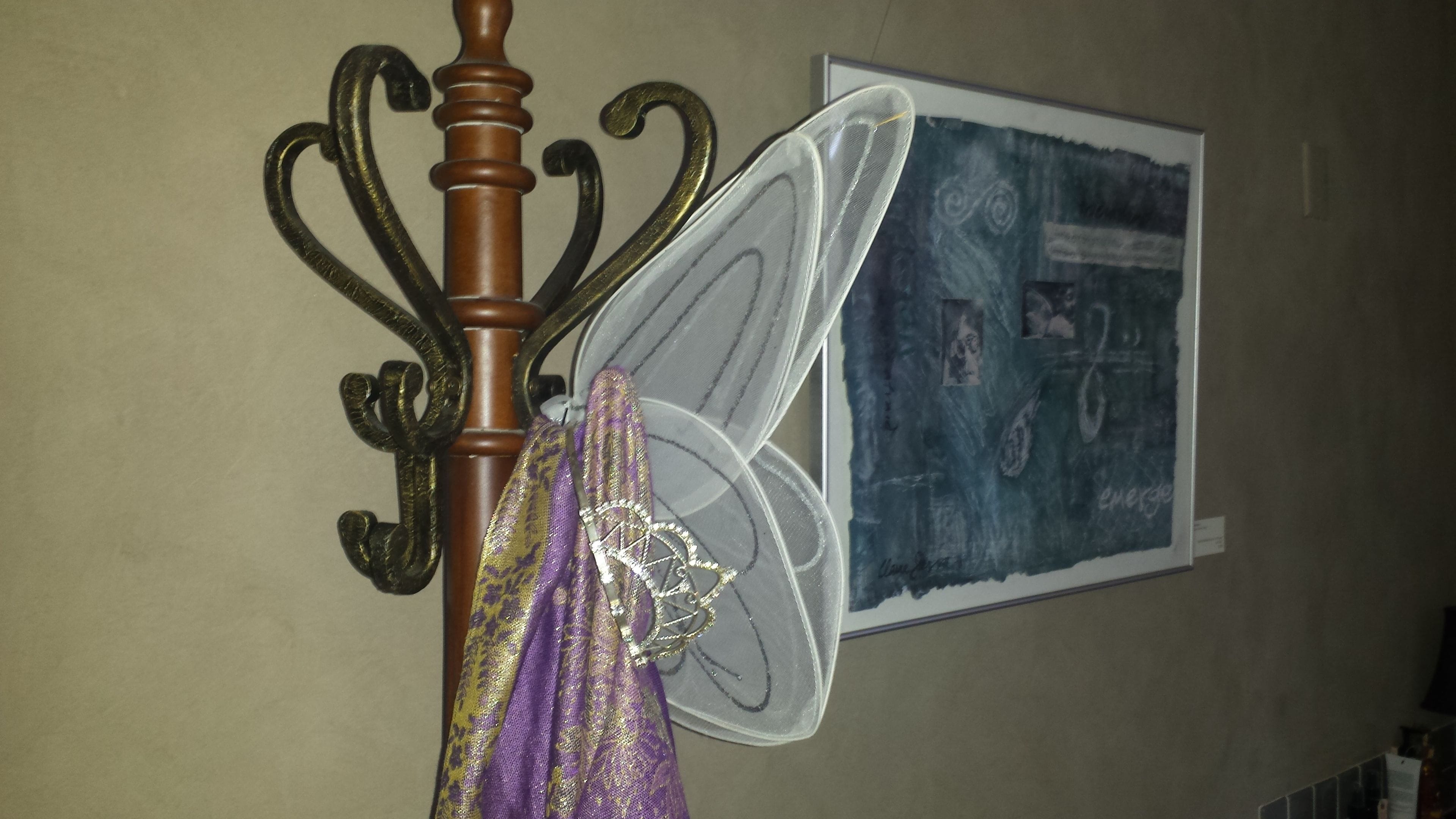 A room with a bed, a wall-mounted artwork, and a decorative item.