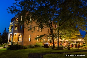 A brick building with a balcony and a well-lit outdoor area. - Balch Hotel (Dufur)