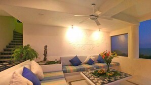 Una sala de estar moderna con un sofá, una mesa de centro y vistas al mar.