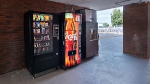 A vending machine with a Coca-Cola logo, a snack vending machine, and a beverage dispenser. - Motel 6 Montgomery, AL - Coliseum (Montgomery)